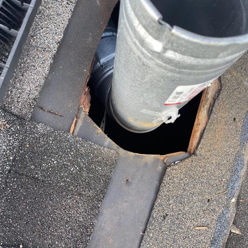 Roof ventilation pipe with damaged surrounding shingles