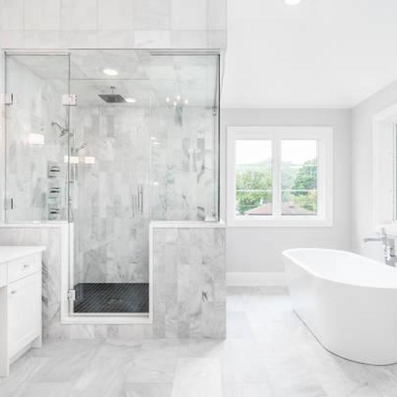 Glass shower enclosure with marble tile walls