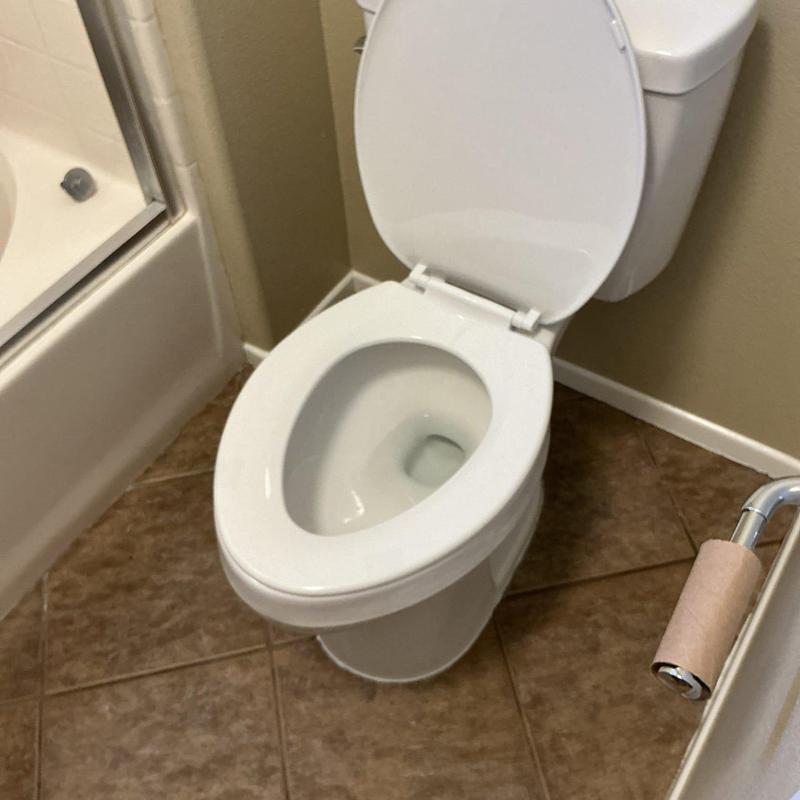 Toilet replacement in master bathroom with empty toilet paper roll