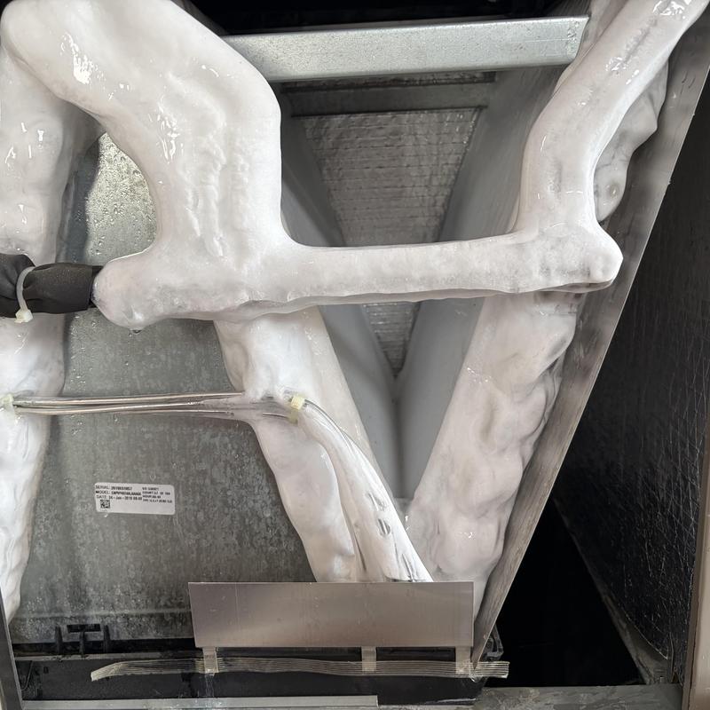 Frozen evaporator coil covered in thick ice buildup Frozen evaporator coil covered in thick ice buildup