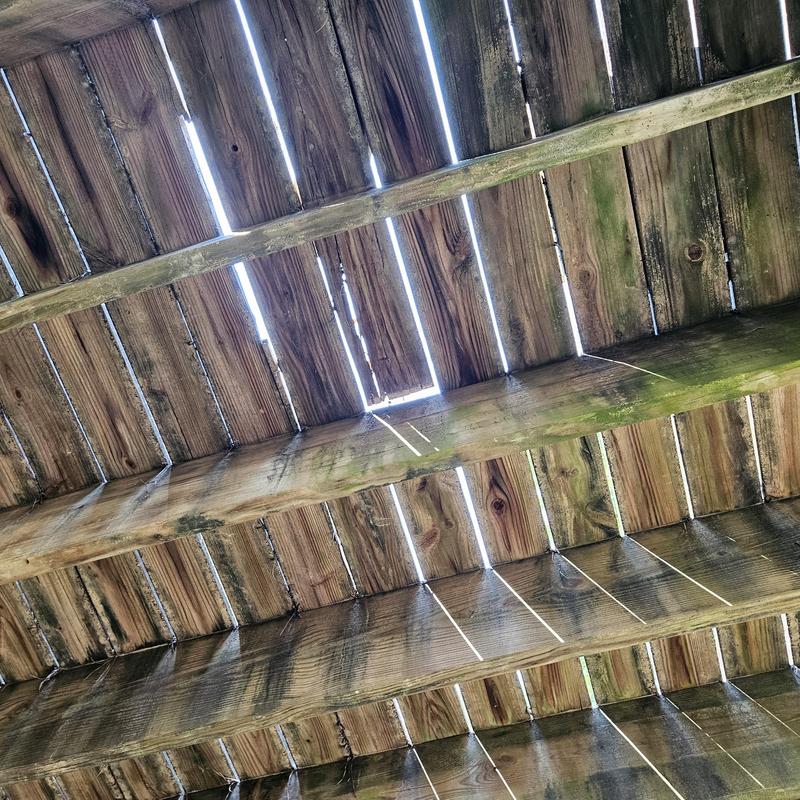 Wooden deck boards with weather damage and gaps Wooden deck boards with weather damage and gaps