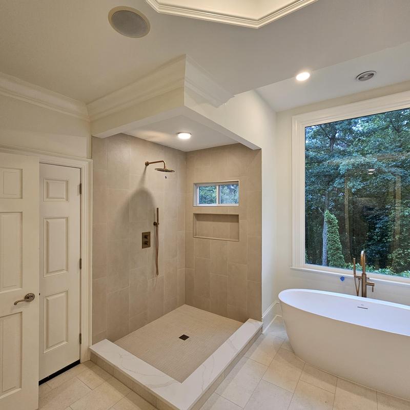 Tiled walk-in shower with bronze fixtures and window niche Tiled walk-in shower with bronze fixtures and window niche