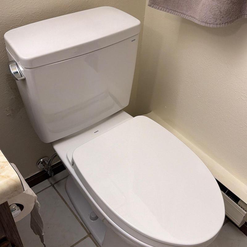 Toilet with closed lid in bathroom corner Toilet with closed lid in bathroom corner