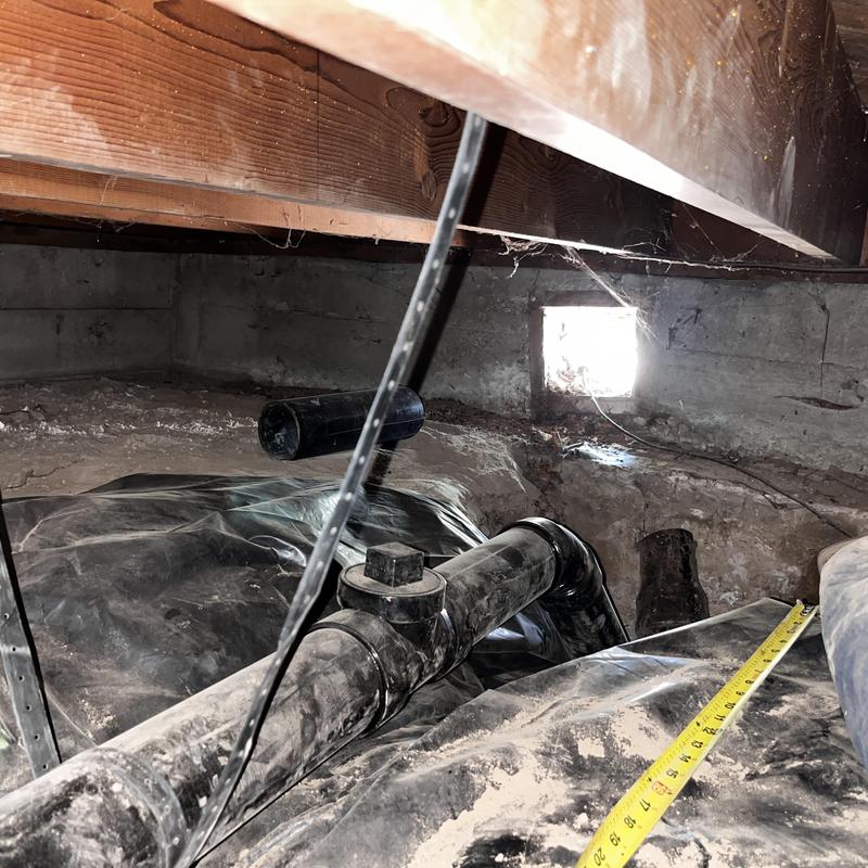 ABS drain pipe installation in crawl space with measuring tape ABS drain pipe installation in crawl space with measuring tape