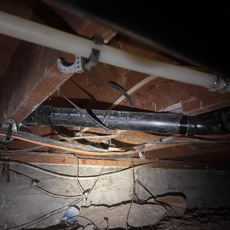 ABS drain pipe installed in crawl space under house beams ABS drain pipe installed in crawl space under house beams
