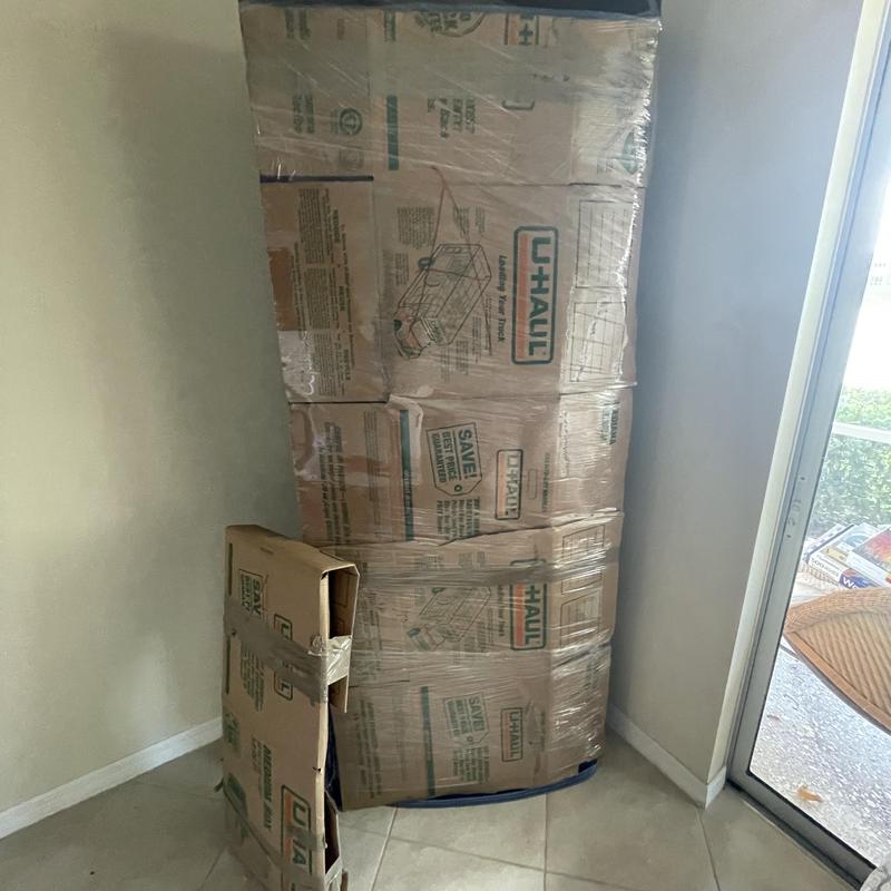Furniture wrapped in moving boxes inside apartment
