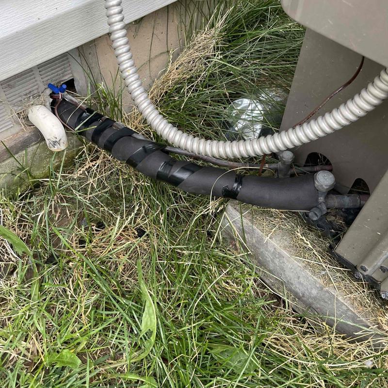 Air conditioner refrigerant line with insulation wrap outdoors