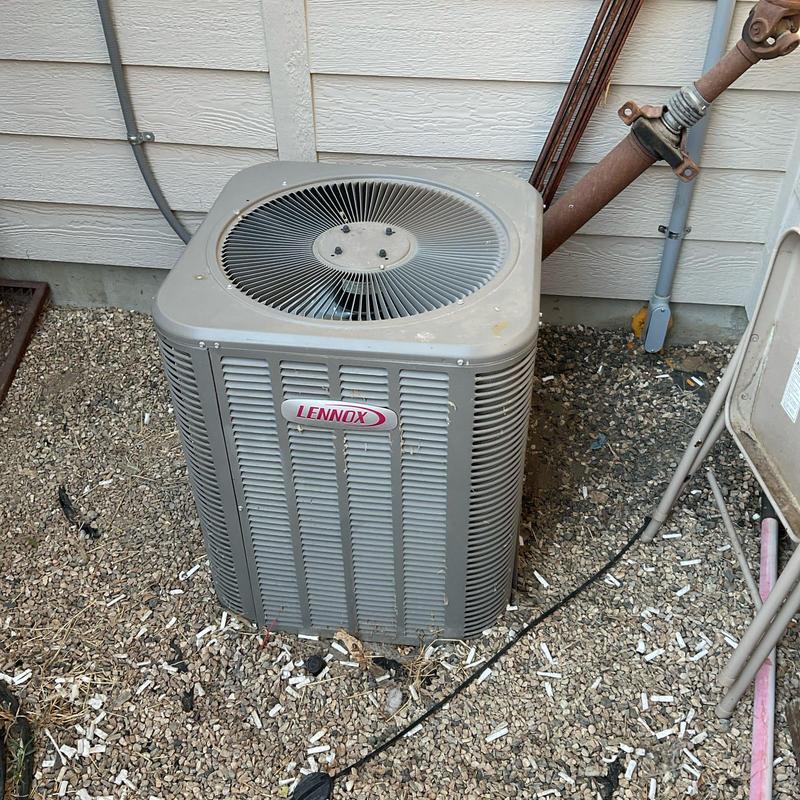 Lennox air conditioner unit on gravel near wall