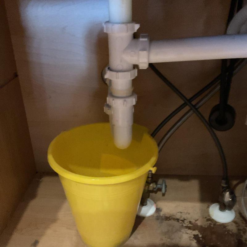 Kitchen sink tubular P trap with yellow bucket underneath