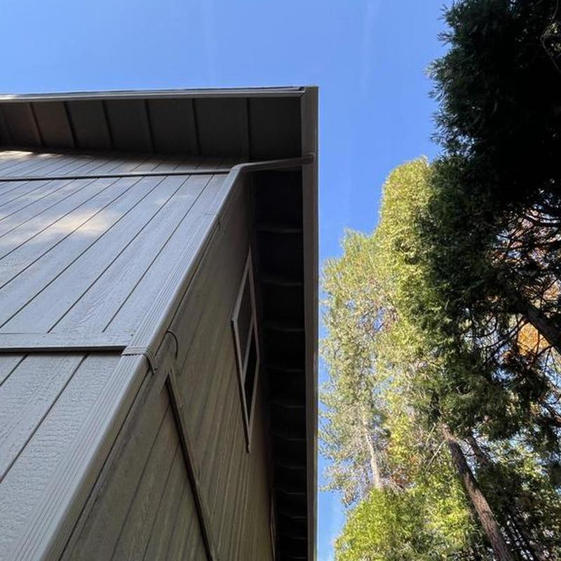 Seamless steel gutters with leaf guards on cabin