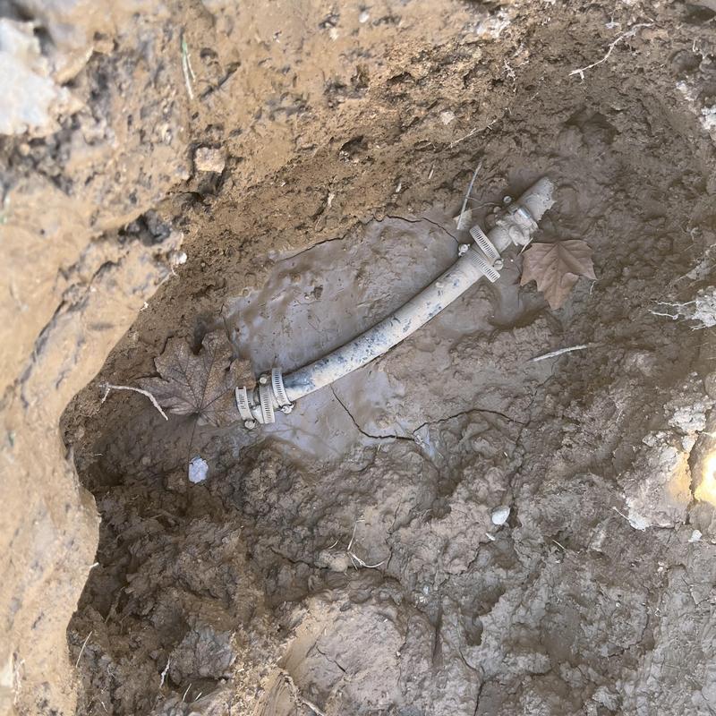 Main water service line with repair clamps in soil