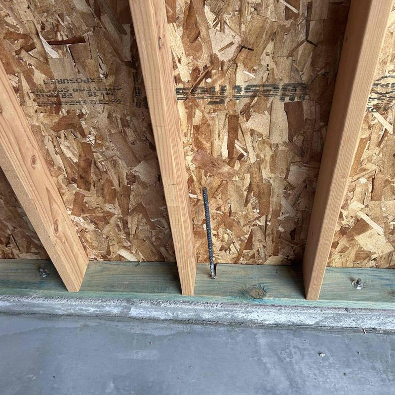 Garage wall framing with exposed wooden studs and OSB sheathing