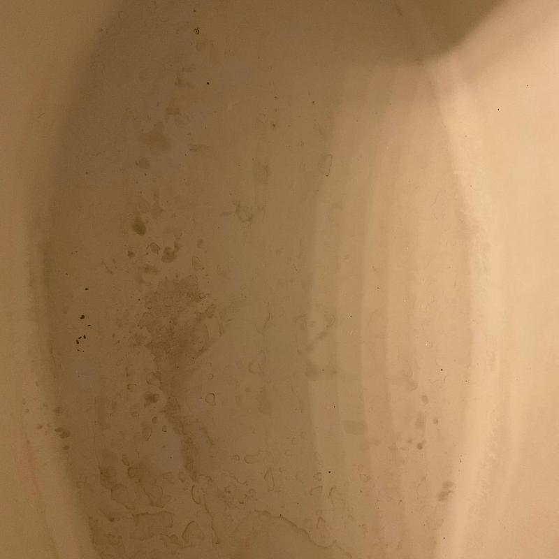 Bathtub interior with water stains and cracks
