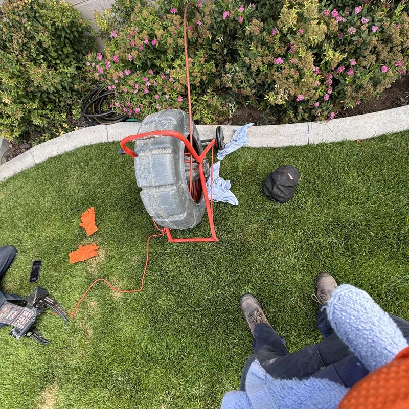 Sewer pipe inspection camera on lawn near shrubbery