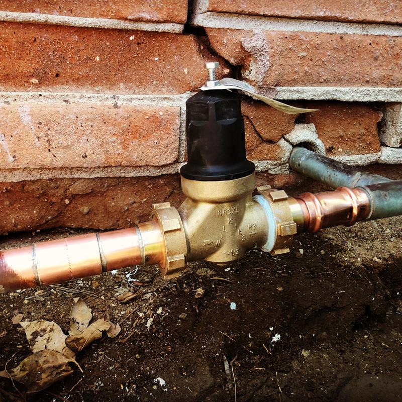 1.5 inch brass water pressure regulator installed on pipe