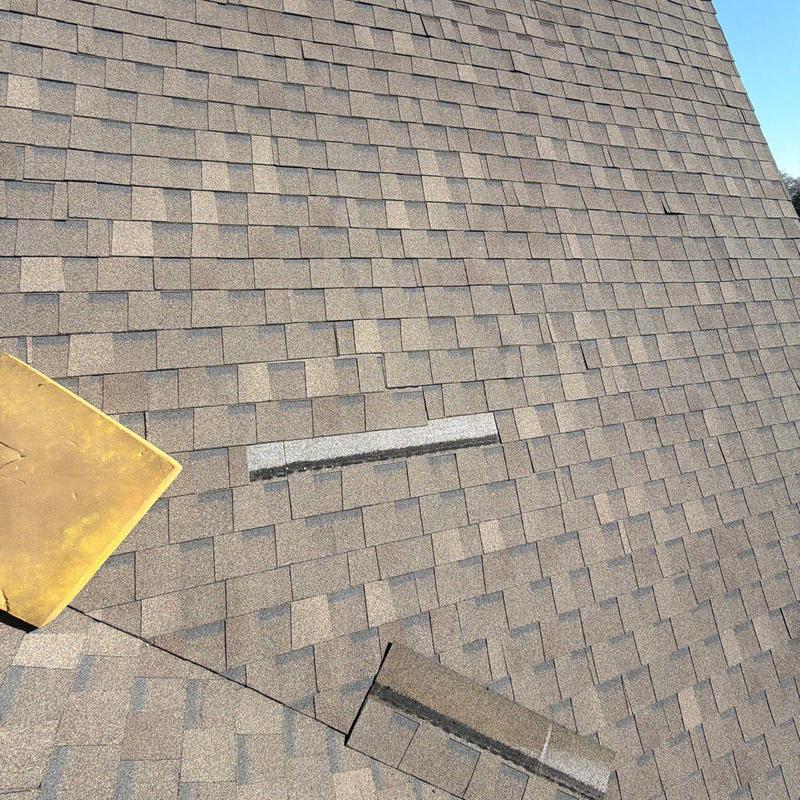 Asphalt roof shingles with visible hail damage marks