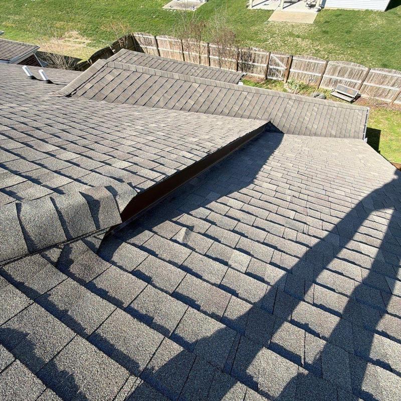 Asphalt shingle roof with metal flashing and hail damage