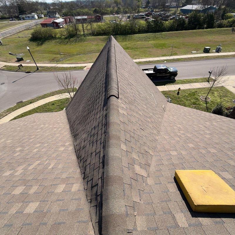 Asphalt shingle roof ridge inspection with hail damage
