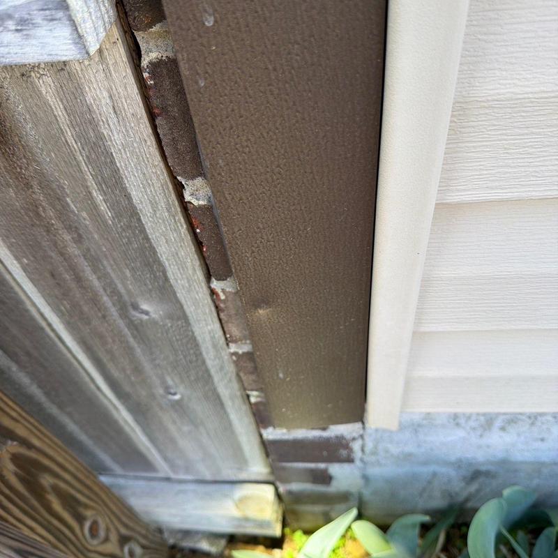 Vinyl siding and trim gap near wooden fence
