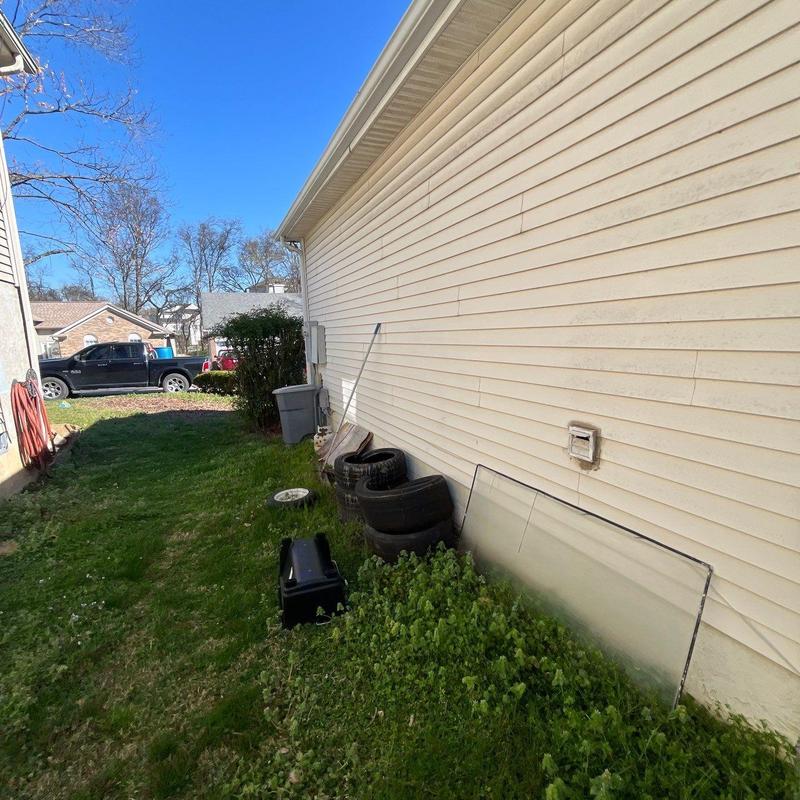 Vinyl siding exterior wall with yard debris