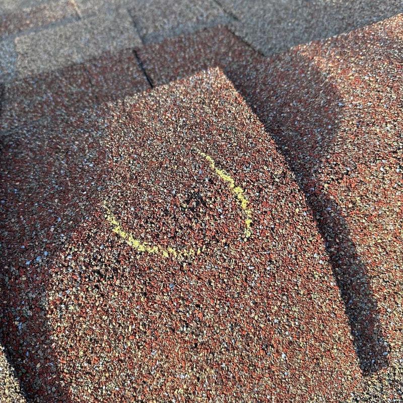 Asphalt shingle roof with marked hail damage