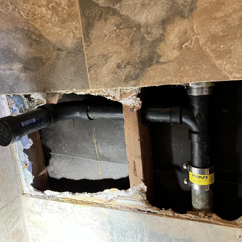 Vanity sink ABS drainage piping behind wall tile