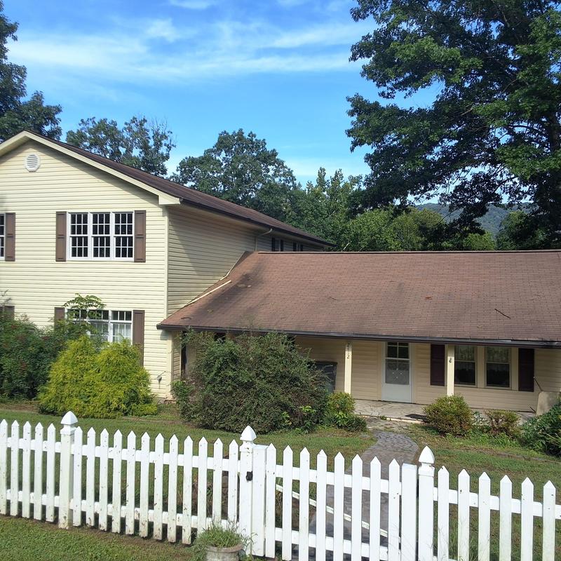 Asphalt shingle roof on house with white picket fence