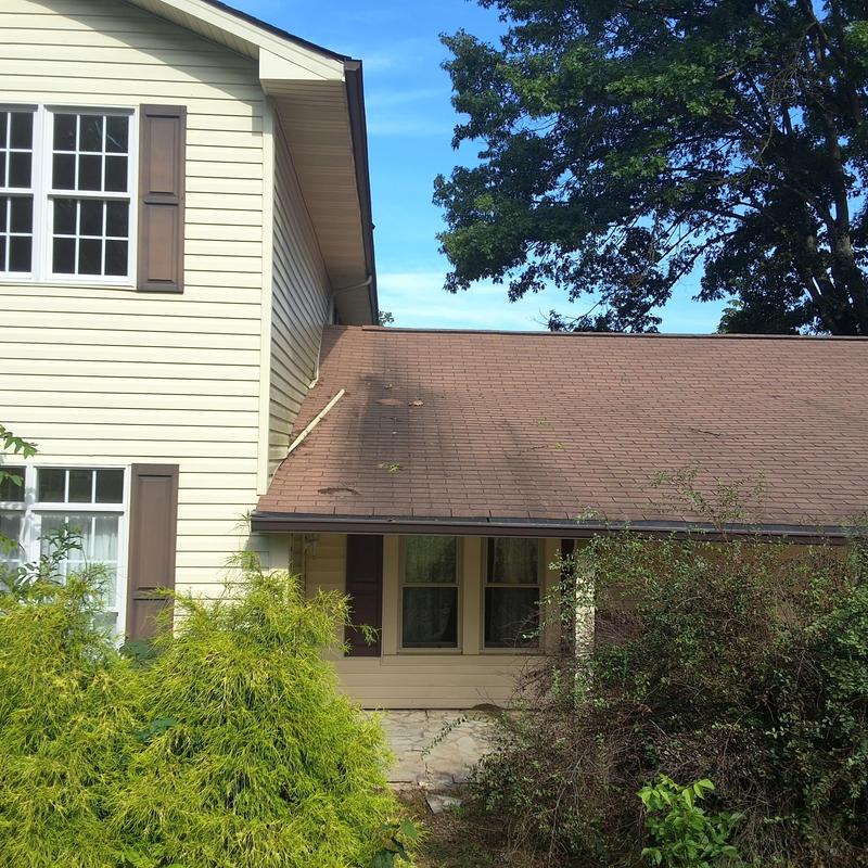 Asphalt shingle roof with damage on a house exterior