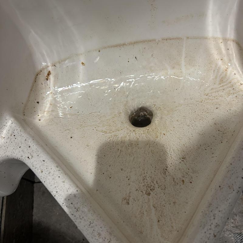 Urinal drain clogged with mineral buildup and debris Urinal drain clogged with mineral buildup and debris