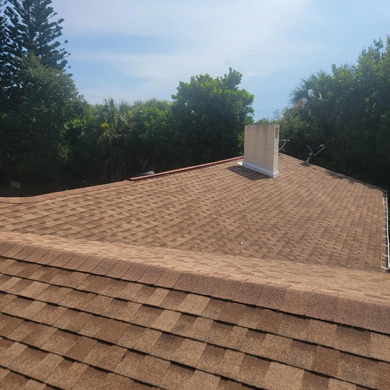 Brown shingle roof with chimney and no visible damage Brown shingle roof with chimney and no visible damage