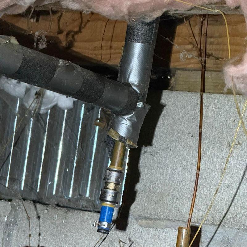 PEX water line with insulation and fittings in crawl space