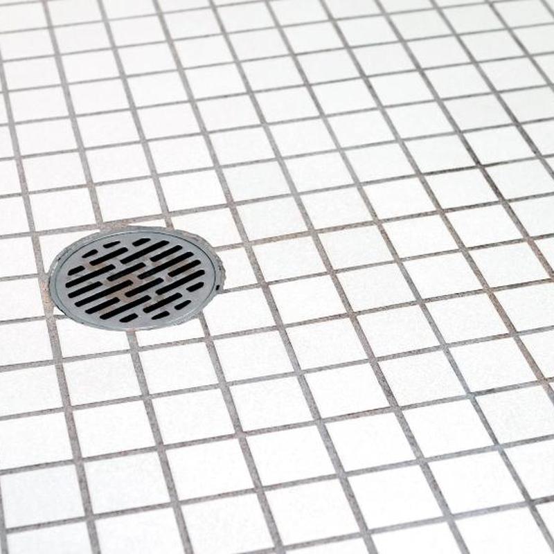 Shower floor drain and tiled surface in master bathroom