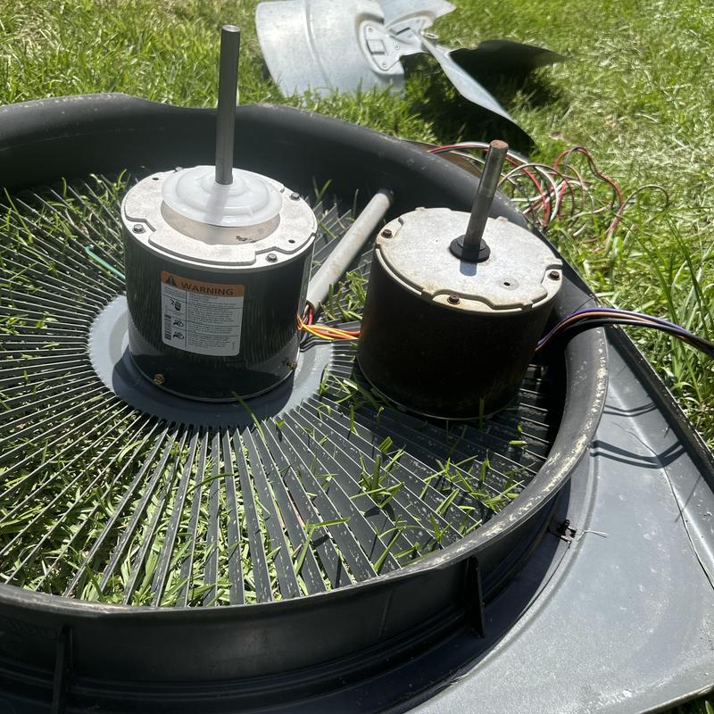 Condenser fan motors side by side on unit grille outdoors Condenser fan motors side by side on unit grille outdoors