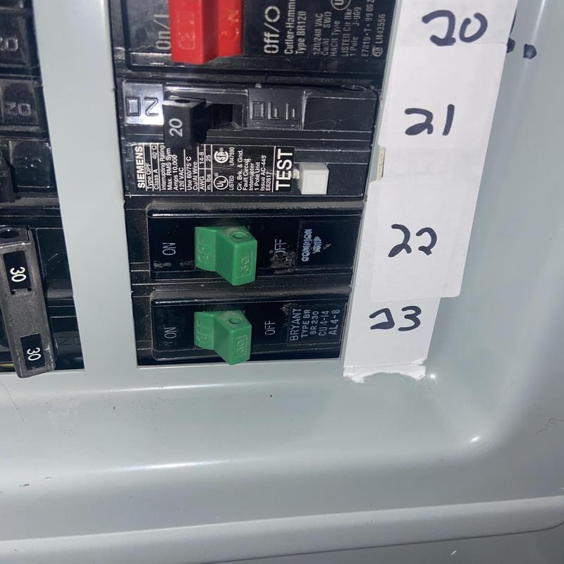Circuit breakers with green breaker switches in panel box