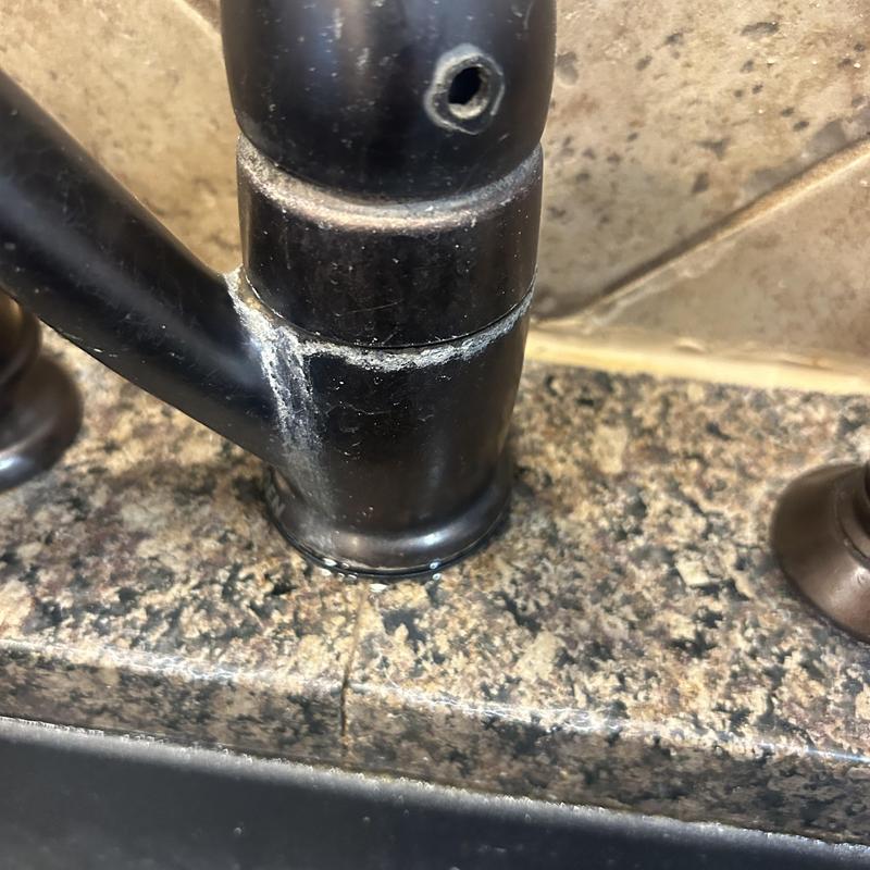 Kitchen faucet base with mineral buildup and leak evidence