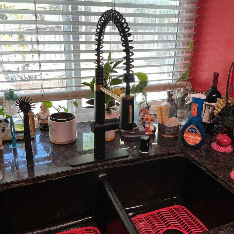 Black commercial style kitchen faucet installation on countertop