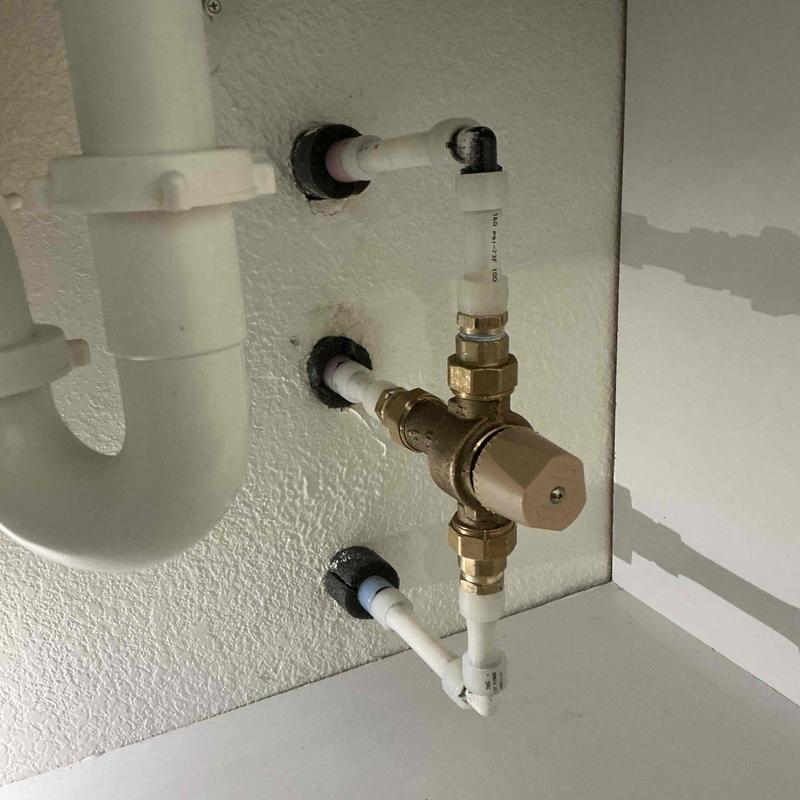 Thermostatic mixing valve with attached plumbing pipes