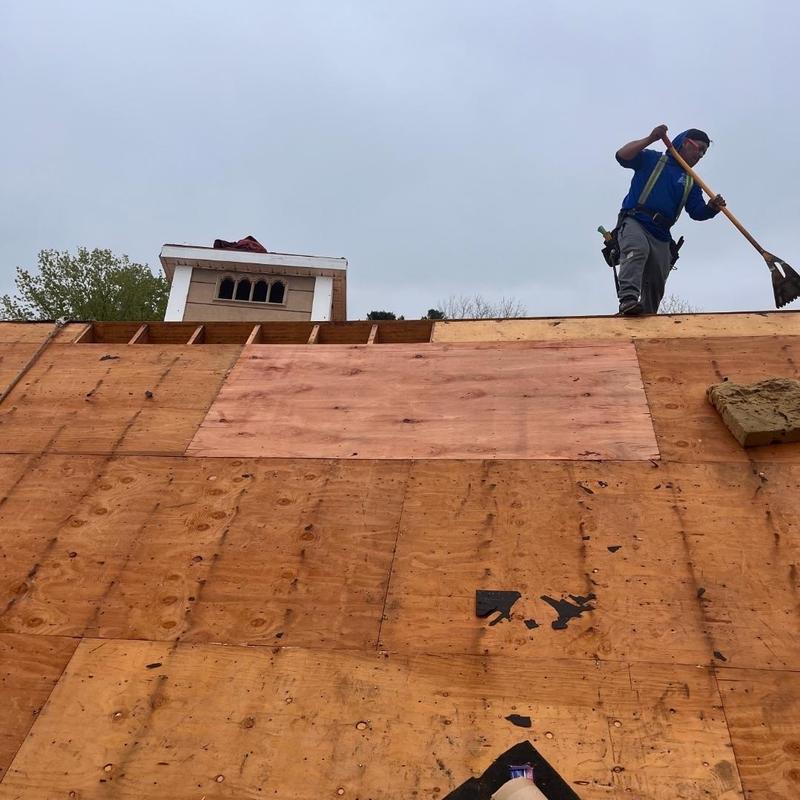 Plywood roof decking with worker cleaning surface
