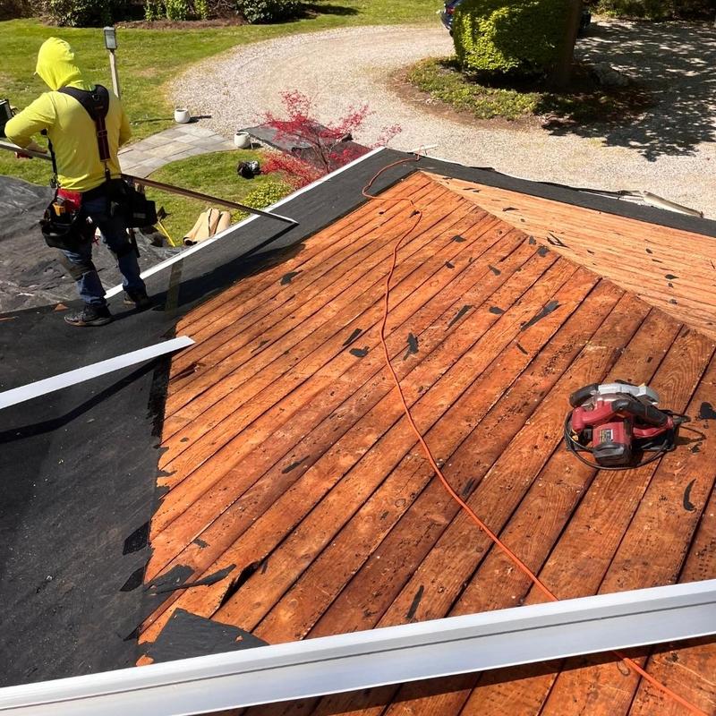 Roof decking with black underlayment being installed