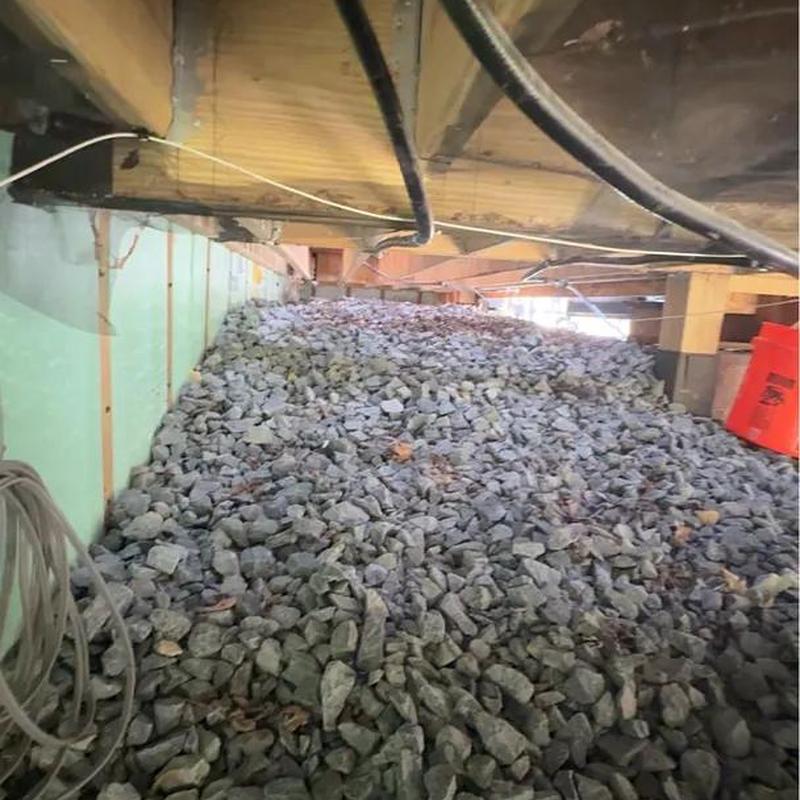 Crawl space with gravel and utility wiring under home