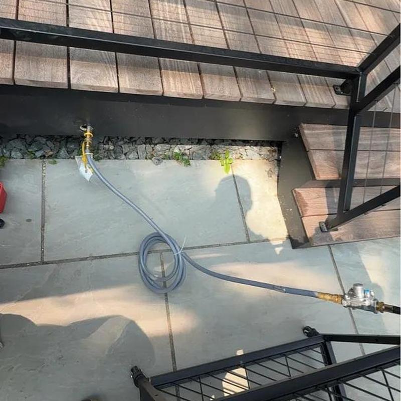 Outdoor grill gas line connection with regulator and hose