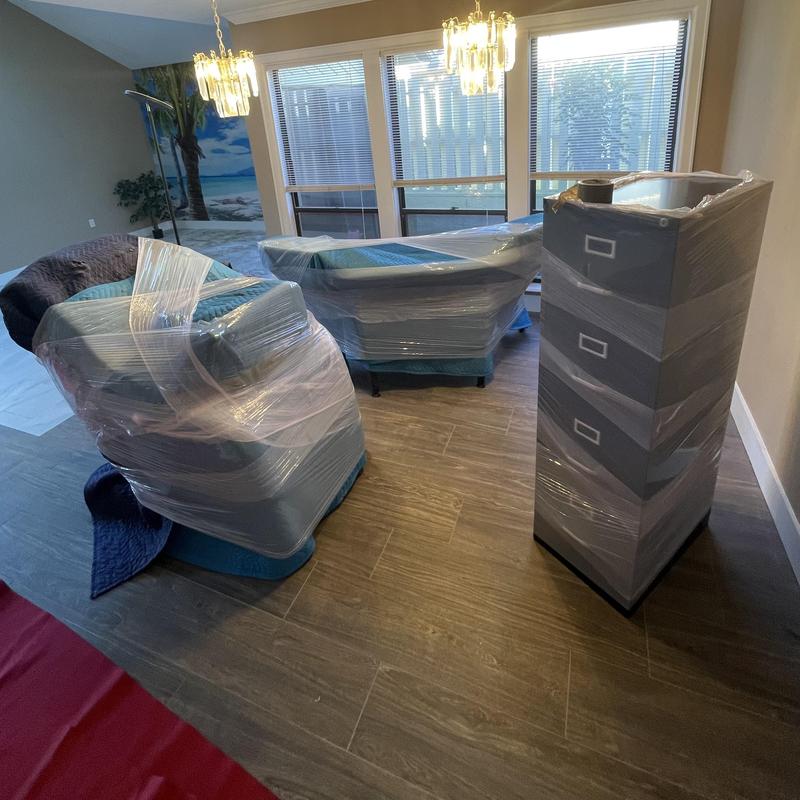 Living room furniture wrapped and floor protected with carpet