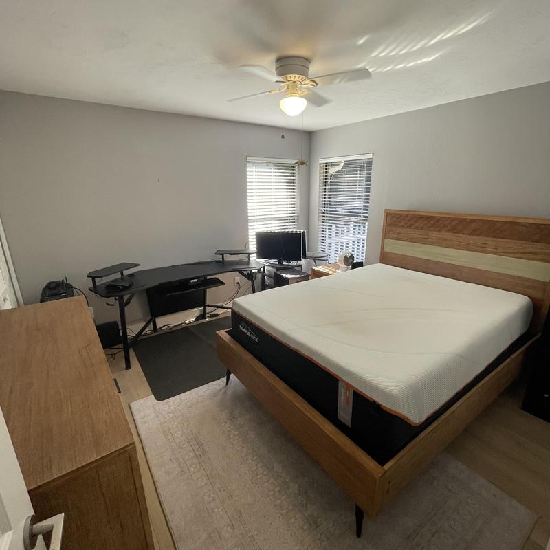 Wood bed frame and mattress in furnished bedroom