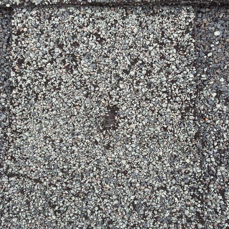 Roof shingle hail damage with granule loss closeup