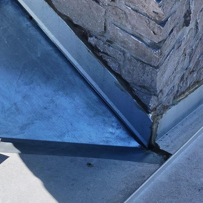Roof flashing corner with weather sealant and stone wall