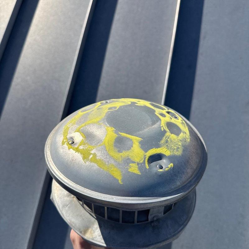 Roof vent cap with hail damage marked in yellow