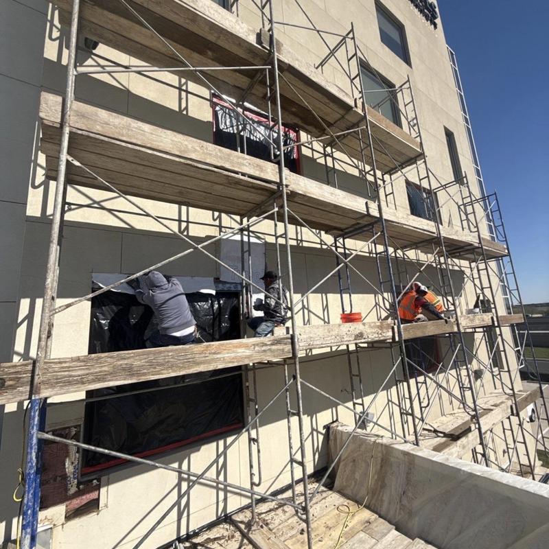 Stucco exterior installation on hotel building scaffold