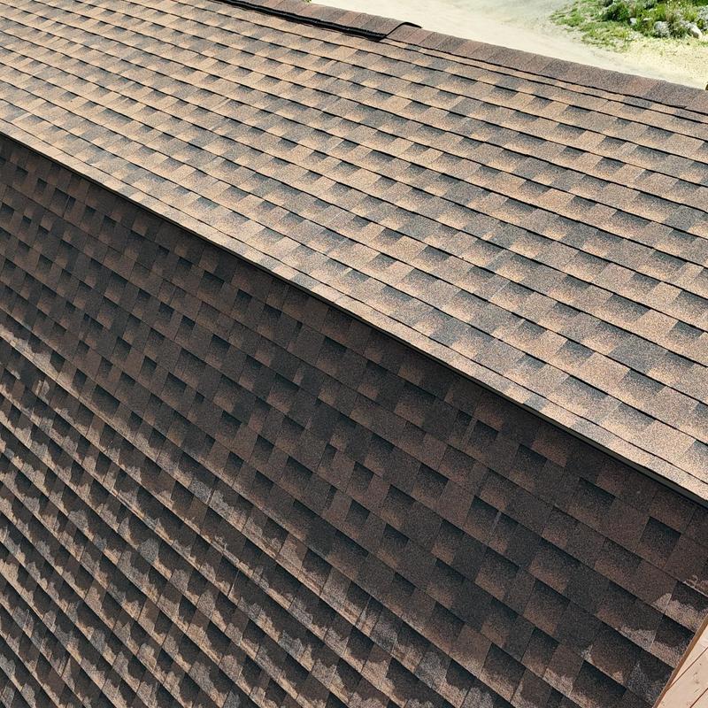Asphalt shingle roof with ridge ventilation and pipe flashing