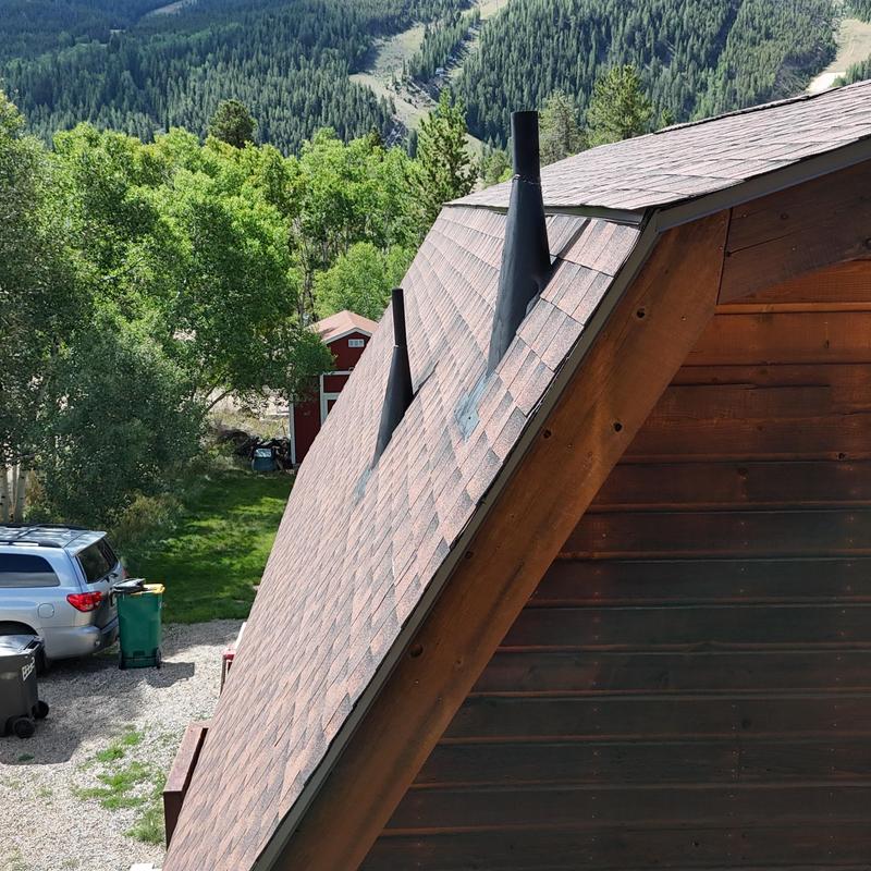 Asphalt shingle roof with pipe vent flashing and ridge vent