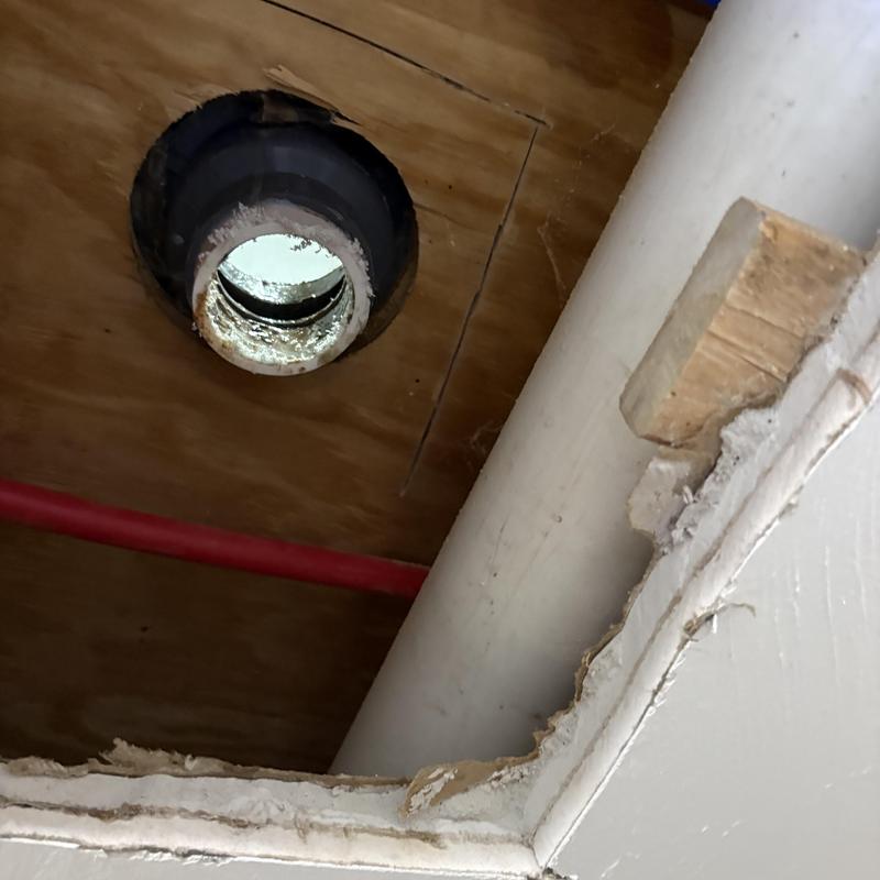Shower drain hole with surrounding wood ceiling structure Shower drain hole with surrounding wood ceiling structure